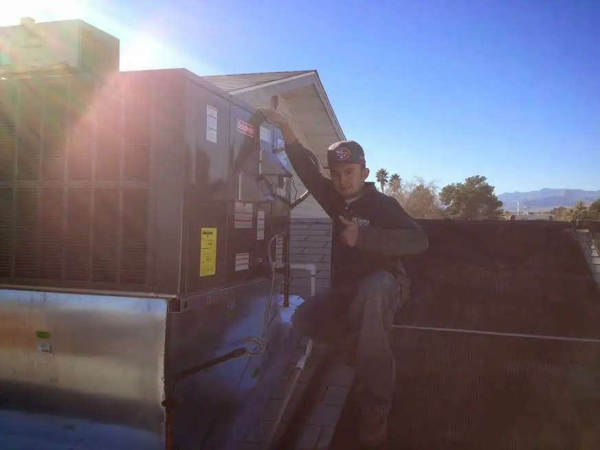 HVAC technician performing AC Tune-Up on a rooftop unit in Andover